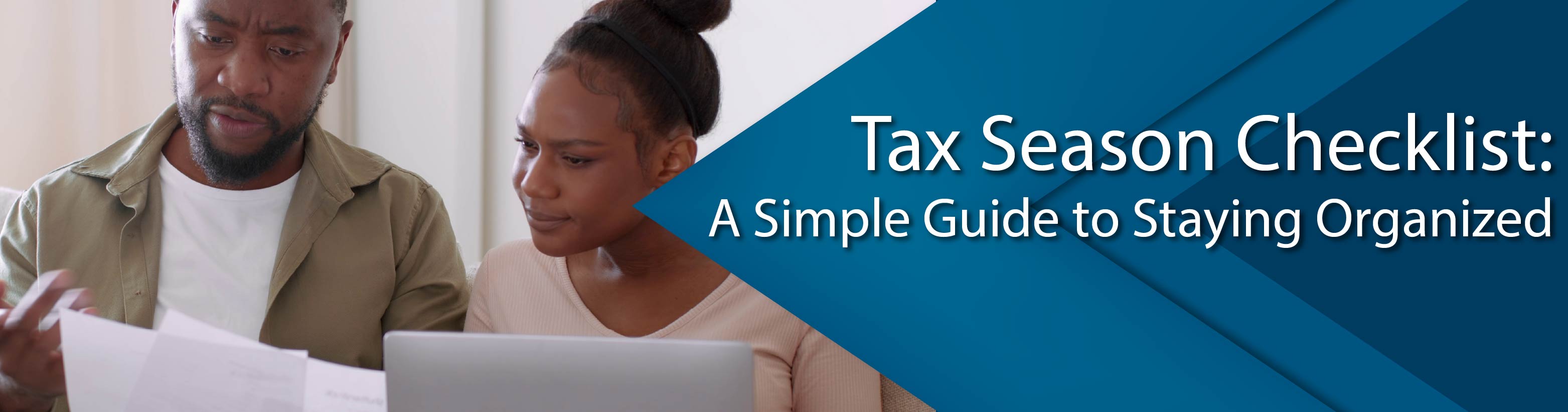 A couple holding papers and a computer filing taxes